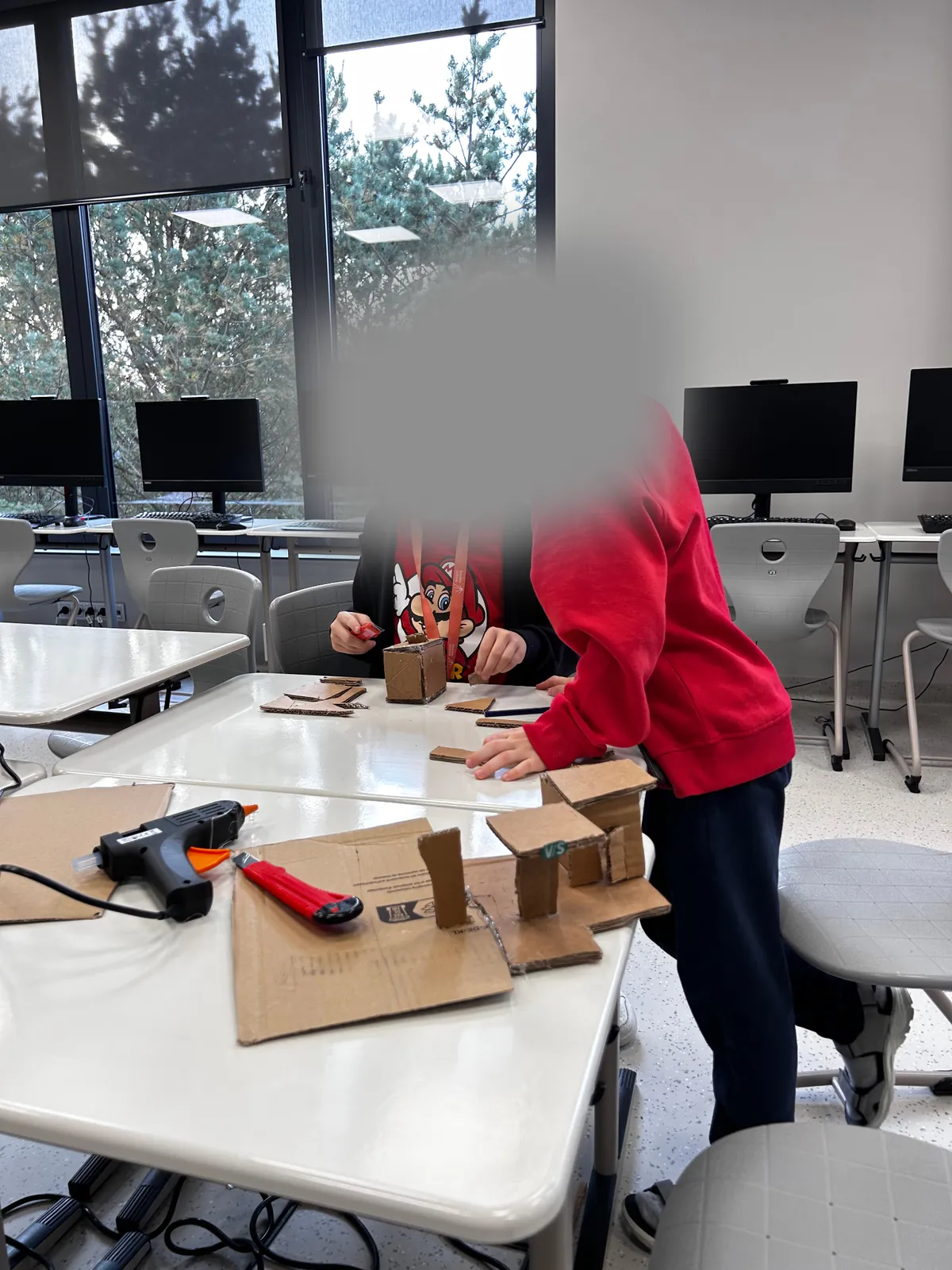 Mokinys konstruoja kartoninį modelį