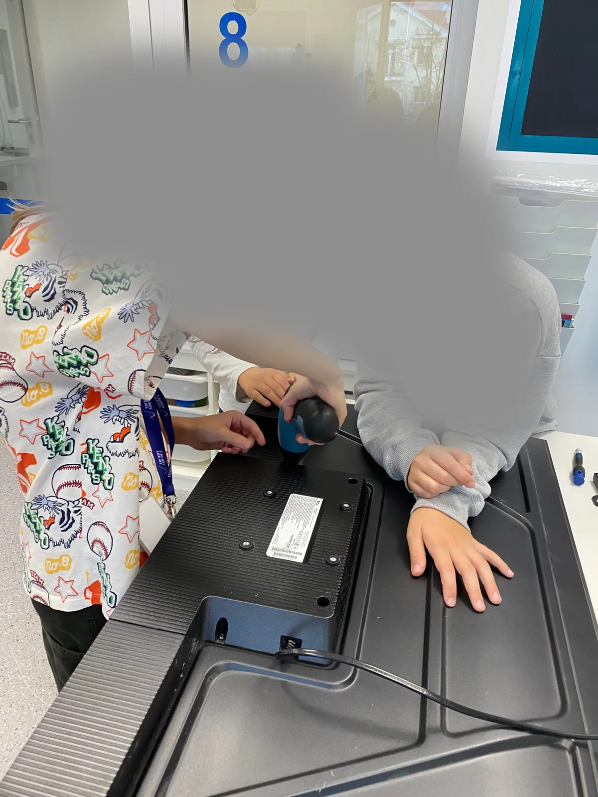Mokiniai tyrinėja atvertą nešiojamąjį kompiuterį